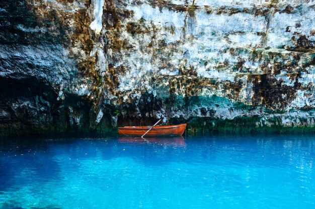 Bateau en bois près d'un rocher escarpé à la surface du lac souterrain Melissani Lake, Kefalonia, Grèce.