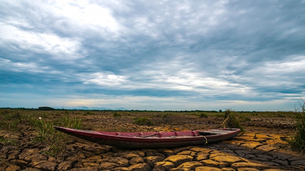 Bateau en bois sur la sécheresse terrestre avec le lever du soleil