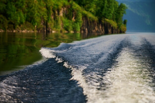 Le bateau coupe la surface de l'eau du lac du lac teletskoye république de l'altaï russie