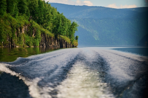 Le bateau coupe la surface de l'eau du lac du lac teletskoye république de l'altaï russie