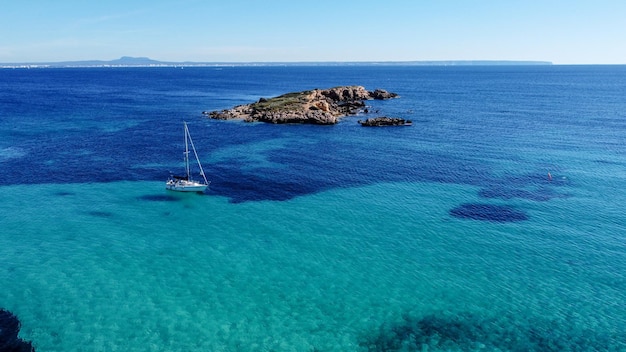 Photo un bateau dans l'eau avec une petite île en arrière-plan