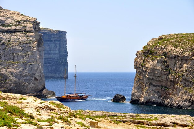 Photo un bateau dans la mer bleue calme contre un ciel clair