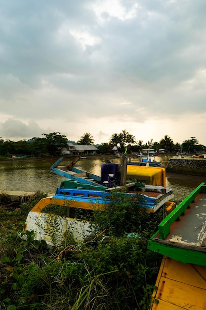 Photo un bateau est amarré dans une rivière avec un ciel nuageux en arrière-plan.