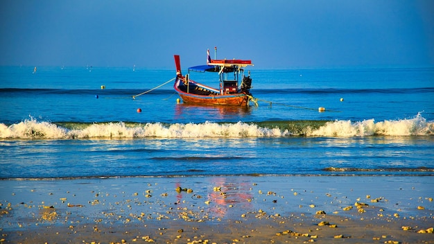 Un bateau est sur l'eau avec le nom du bateau dessus.