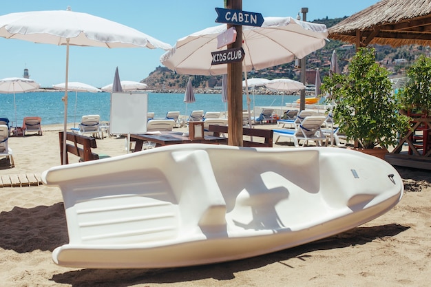 Un bateau en fibre de carbone se trouve sur le sable près de la mer