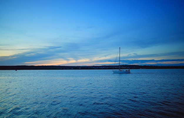 Bateau sur fond de rivière au coucher du soleil