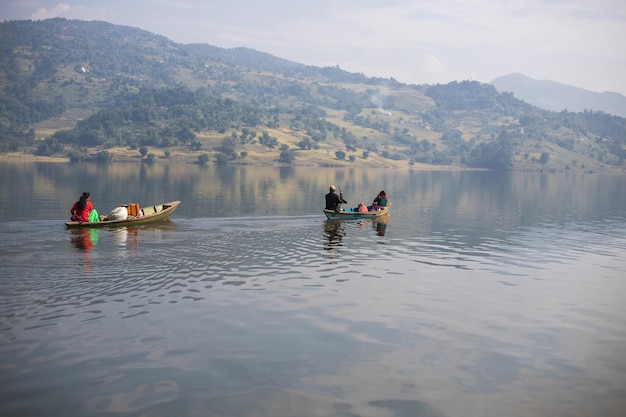 Un bateau avec un homme dessus est dans l'eau et une femme à l'arrière porte une chemise noire.