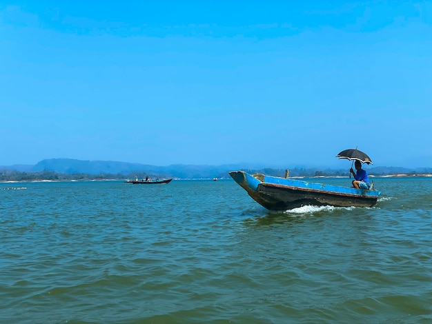 Un bateau avec un homme dessus avec un parapluie