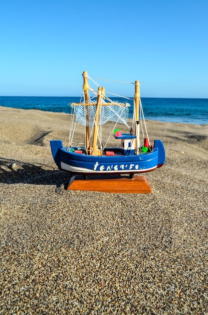 Photo un bateau de jouet sur la plage de sable