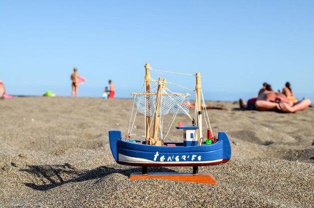 Photo un bateau de jouet sur la plage de sable