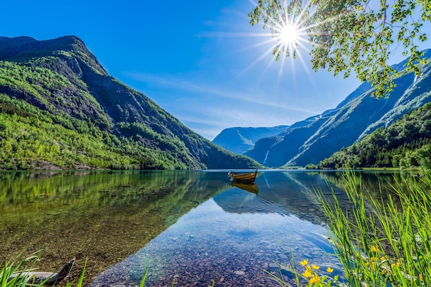 Un bateau sur un lac avec un décor de montagne