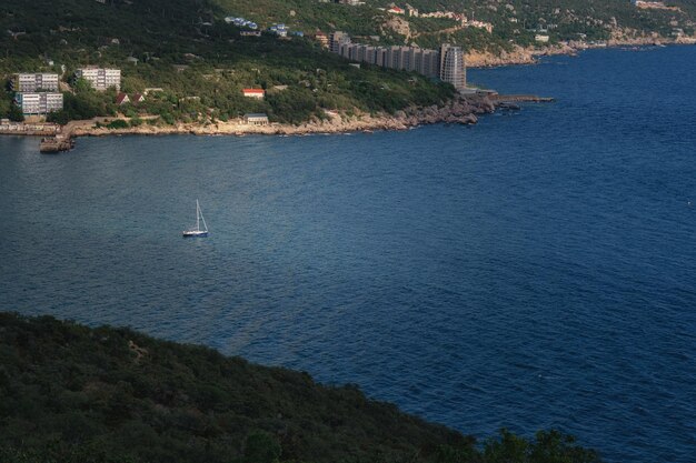 Bateau sur la mer d'azur près de Laspi Belle vue sur les montagnes et la côte rocheuse