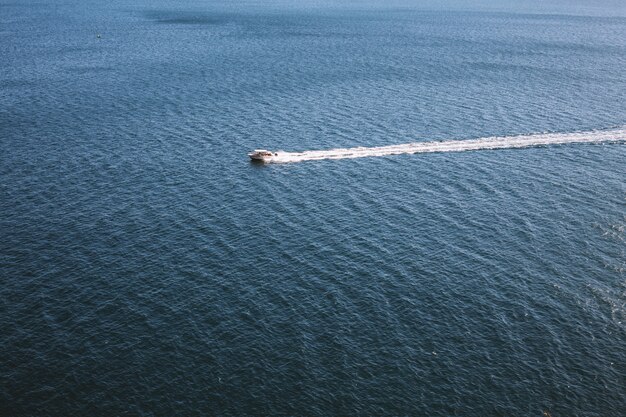 Bateau à moteur blanc sur une surface d'eau de mer