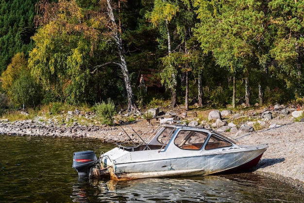 Bateau à moteur près de la rive d'un lac de montagne. Tombe. Russie, Altaï, Lac Teletskoïe