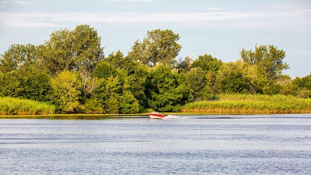 Bateau avec un moteur se précipitant le long de la rivière