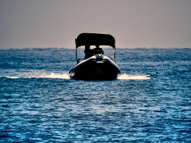 Un bateau naviguant en mer contre un ciel dégagé