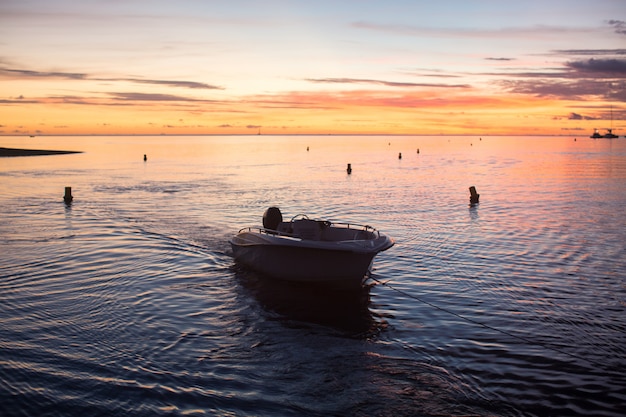 Bateau naviguant sur l'océan au coucher du soleil.