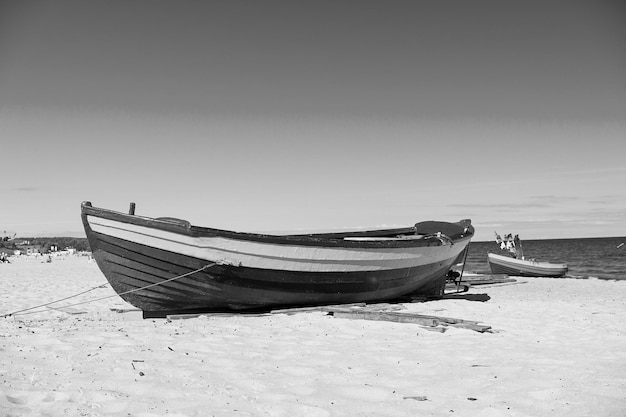 Bateau ou navire navire marin moderne avec peinture colorée à l'amarrage sur une plage de sable ensoleillée en plein air sur fond bleu mer et ciel