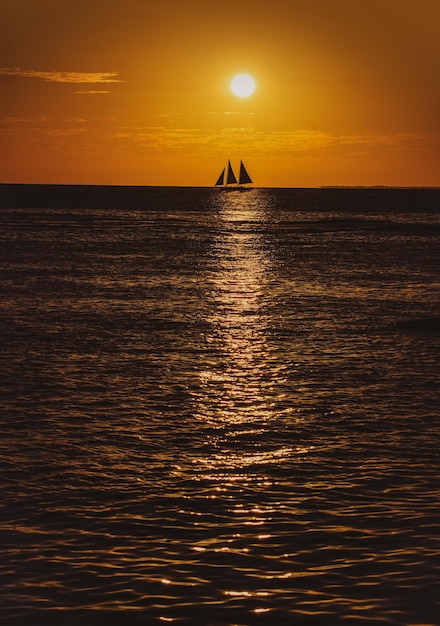 Bateau sur l'océan au coucher du soleil voiliers avec voiles yacht de mer naviguant le long de l'eau