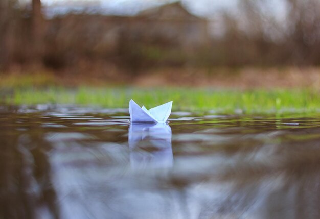 Un bateau en papier flotte dans la rivière