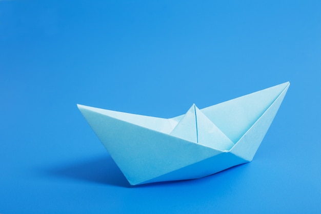 Bateau en papier sur fond de papier bleu