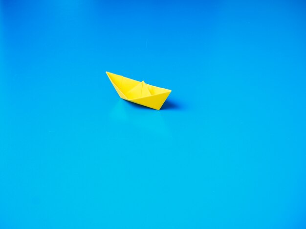 Bateau en papier sur fond de papier bleu