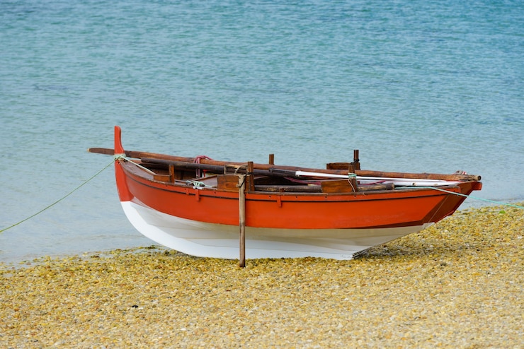 Photo bateau de pêche en bois sèche sur le bord de la mer