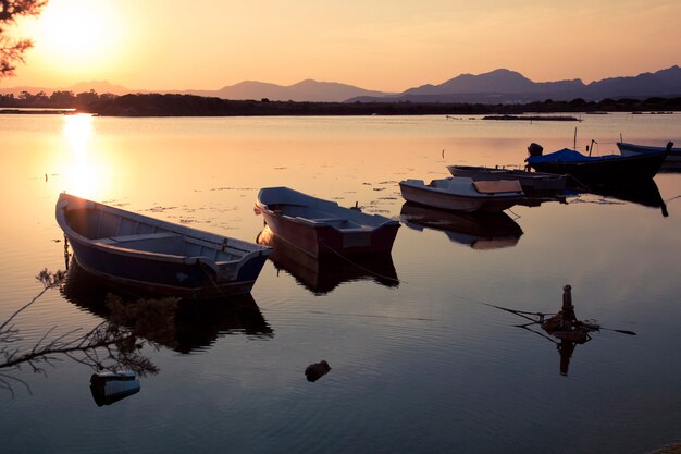 Bateau de pêche dans le lac au coucher du soleil