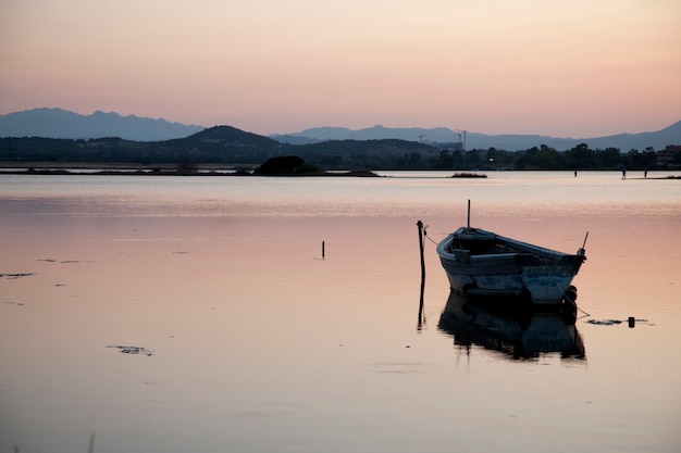 Bateau de pêche dans le lac au coucher du soleil