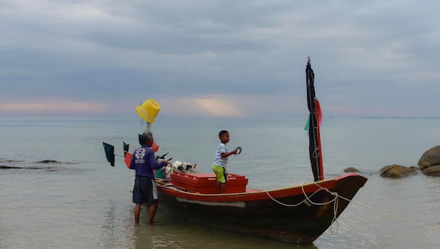 Un bateau de pêche est un bateau pour pêcher en mer Au bord de la mer un bateau de pêche était amarré et sortait au milieu de la merEnregistré le 10 mars 2023 à Rayong Thaïlande