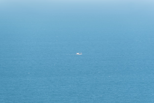 Bateau de pêche est en train de pêcher dans la mer bleue ou l&#39;océan