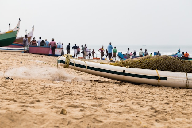 Bateau de pêche avec filet et pêcheurs à l&#39;arrière attendant une prise.