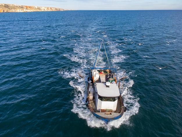 Bateau de pêche flottant dans la vue aérienne de la mer bleue depuis un drone