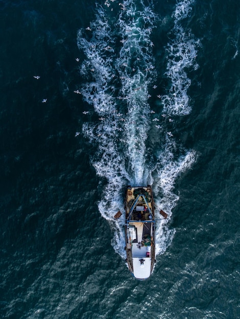 Bateau de pêche flottant dans la vue aérienne de la mer bleue depuis un drone