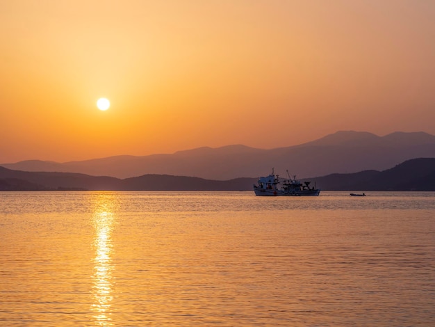 Bateau de pêche et pêche au coucher du soleil dans la mer Egée près de l'île d'Evia en Grèce