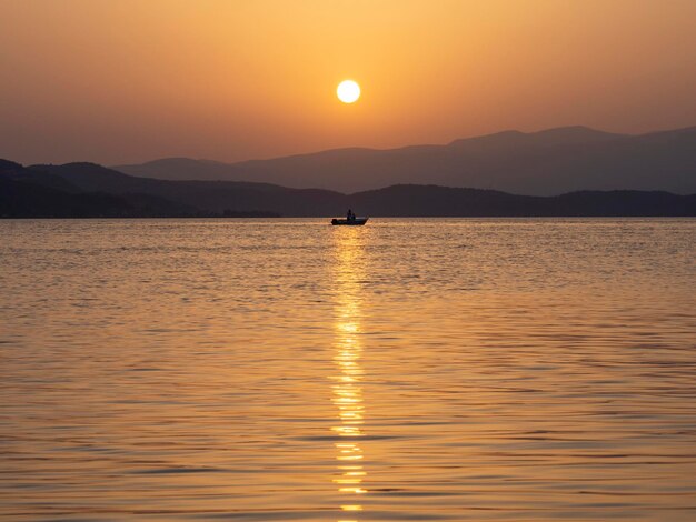 Bateau de pêche et pêche au coucher du soleil dans la mer Egée près de l'île d'Evia en Grèce