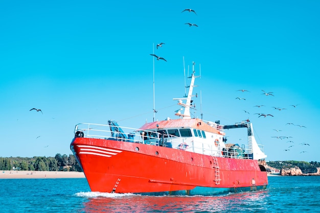 Bateau de pêche rouge ou chalutier naviguant dans l'océan Atlantique