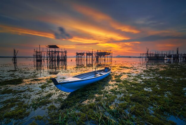 Bateau de pêche traditionnel dans un village de pêcheurs au coucher du soleil sur l'île de Batam