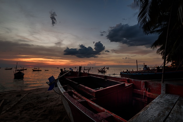 Le bateau de pêcheur sur la plage avec ciel coucher de soleil