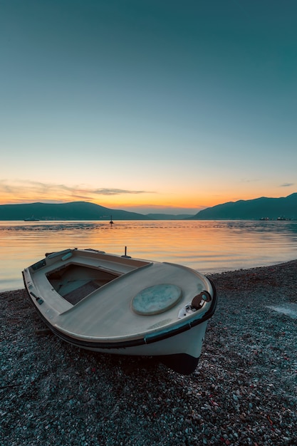 Bateau sur la plage au coucher du soleil.