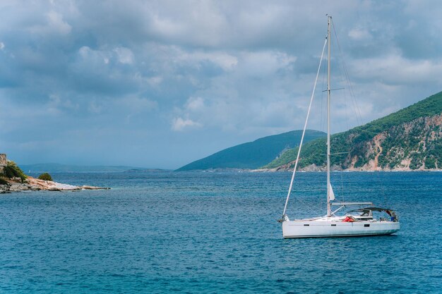 Bateau de plaisance blanc près du port du village de pêcheurs de l'île de Céphalonie Fiskardo Grèce aux beaux jours d'été