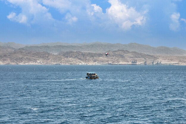 Bateau de plaisance pour voyager en Mer Rouge, en Israël. Sur fond de littoral et de montagnes.