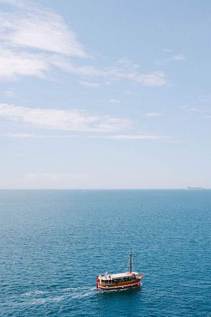 Un bateau de plaisance rouge navigue sur la mer