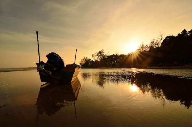 Bateau près de la plage quand le soleil se couche