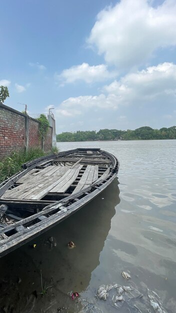 Un bateau qui transporte des personnes et des marchandises Debout au bord d'une rivière par beau temps