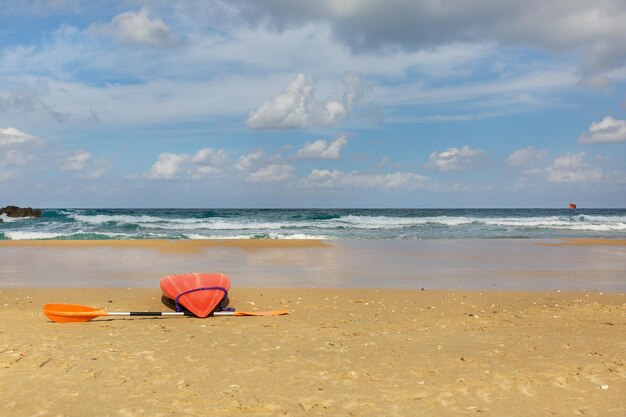 Bateau rouge sur la plage sur fond de ciel