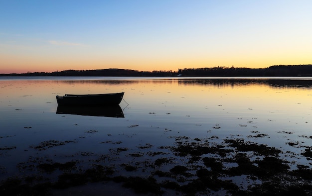 Bateau solitaire dans le fjord de Roskilde au Danemark pendant le coucher du soleil