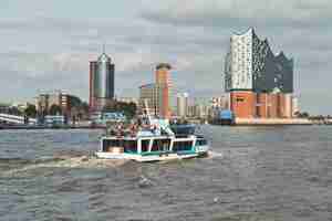 Photo bateau avec des touristes va sur l'elbe vers elbphilharmonie à hambourg