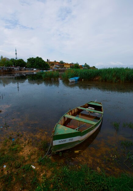 Photo un bateau vert est dans l'eau avec un bateau vert dans l' eau