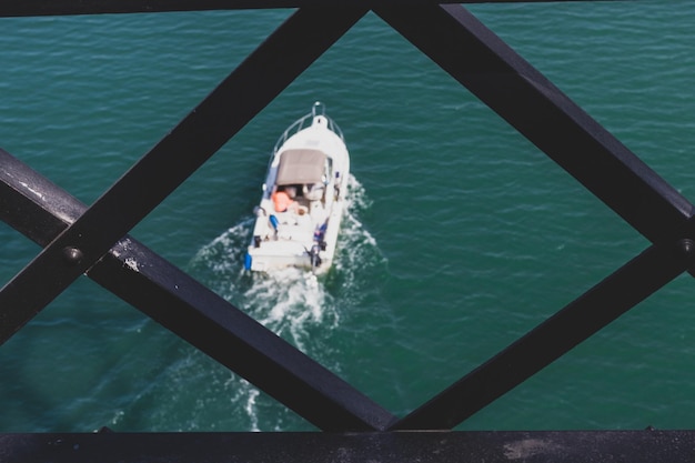 Bateau de vitesse vu à travers une grille de fer encadrée abstraite